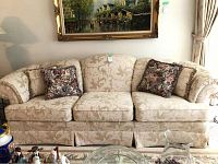Front view of three-seat sofa with damask upholstery and pillows