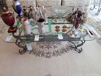 Full view of the coffee table from above showing glass top and metal base with various items on top removed as per seller note.
