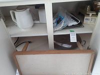 Photo shows a white electric kettle, a serving platter, a Weight Watchers kitchen scale, and some additional kitchen items on a shelf.