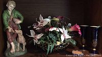 Boy with dog ceramic figurine paired with flower bowl and two vases on shelf