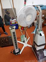 Hoover upright vacuum with three floor fans and vintage carpet sweeper in background