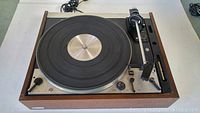 Top view of Dual 1229 A turntable showing platter, wooden frame, power cord