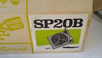 Box art showing the Garrard SP20B turntable with branding and model details.
