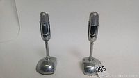 Front view of paired microphone bookends showcasing their size and shape against a plain background with lot tag 205.