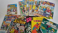 Photo showing assortment of Archie Comics including Jughead & Archie, Betty and Veronica, Life with Archie, Booster Gold, and Walt Disney titles, fanned out to show some cover art.