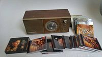 Photo shows vintage Granada radio with wood casing next to a collection of classical music CDs with various artwork.