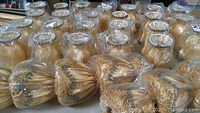 Lot of 32 new mini lamp shades wrapped in plastic, various small sizes and shapes, beige color with decorative trim