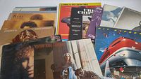 Photo showing 16 mixed vinyl record albums with various artists including Barbra Streisand, Carole King, Reba McEntire, and Nat King Cole tribute. Covers appear in lightly used condition.