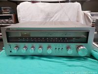 Front view of the vintage JVC R-S5 stereo receiver showing tuner dial, control knobs and switches on a silver metal panel.