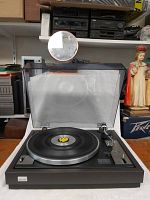 Sansui FR-1080 turntable with open dust cover showing platter, tonearm, and controls.