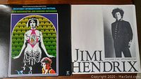 Two vinyl LP album covers laid open, one with colorful psychedelic front cover featuring Jimi Hendrix and Otis Redding, the other with black and white photos of Jimi Hendrix performing live and text inside the cover.