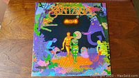Front cover of Santana Amigos vinyl album with colorful psychedelic art and title.