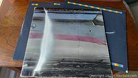 Front of Wings Over America album cover showing reflective silver surface with some wear and minor scratches