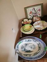 Photo of mixed platters, plates, cutting board, server, and cheese tray arranged on wooden surface.