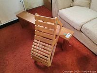 Two wooden yoga benches on a red carpeted floor, one long flat bench and one smaller slatted inclined bench leaning against it