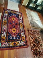 Three small rugs laid on hardwood floor, showing overall patterns and condition