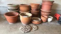 Overview of clay and plastic pots with two stone tiles