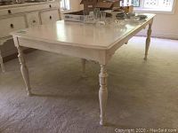 Front angled view of the painted vintage wood dining table showing turned legs and surface.