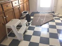 Photo of the step stools, waste bins, and mats placed on a checkered floor showing size and condition.