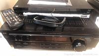 Photo showing JVC RX-6510V receiver with remote and Sony Blu-ray player stacked above it