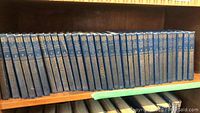 Full front view of 32 volumes of the Chronicles of Canada series arranged on a bookshelf, clearly showing uniform blue bindings with gold titles and decoration.