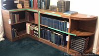 Overall view of the three-section vintage corner bookcase with multiple shelves and assorted books.