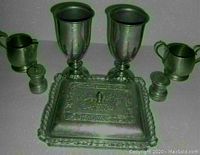 Photo showing two 7-inch pewter goblets, creamer, sugar bowl, and salt and pepper shakers arranged around the covered dish.