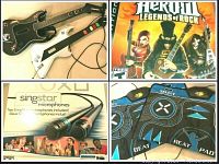 Photo showing two PlayStation Guitar Hero guitars (black Kramer WiGiuitar and white Legends of Rock), Guitar Hero Legends of Rock game cover, SingStar microphones box, and Mad Catz beat pads