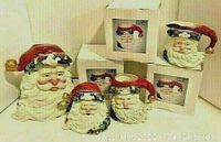 All pieces in the Santa Claus figural coffee set, including cookie jar, sugar bowl, creamer, and four mugs in original packaging with plastic wraps.