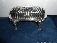 Silver plated footed serving platter with ornate legs and ribbed domed lid