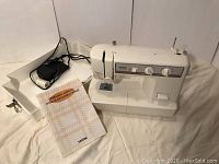 Brother VX-1120 sewing machine with power cord, foot pedal, and instruction manual displayed on a white surface.