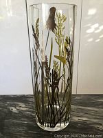 Front view of clear cylindrical vase with silver and green botanical silkscreen