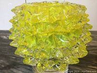 Side view of yellow Murano glass bowl showing spiked and textured design.