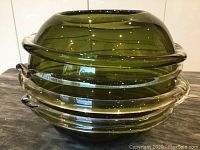 Front and angled view of large green Venetian glass bowl showing its rolled rim and clear glass coil accents.