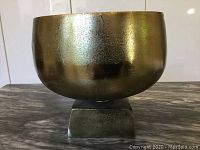 Front and side views of mid-century modern metal bowl on square base.