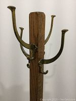 Close-up photo of top iron hooks on oak coat rack showing detail and finish.
