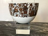 Side view showing brown and white medieval knight and floral design around bowl exterior with some rim wear.