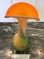 Photo of mid-century Murano mouthblown vase with vibrant orange flared rim and swirled green and cream glass body