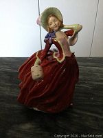 Front angle of Royal Doulton Autumn Breezes figurine showing full dress and bonnet details.