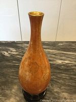 Front view of vintage orange Carlton Ware vase showing the color, shape, and slightly raised spots on the surface.
