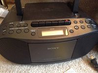 Front view of Sony CFD-S70 CD cassette radio recorder showing control buttons, LCD display, and speakers.