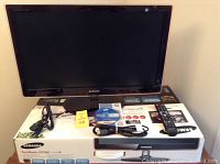 Samsung 27-inch SyncMaster P2770 monitor on original box with remote, cables, manual, and driver CD.