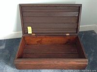 Open antique wooden chest showing the interior wooden construction and hinged lid.