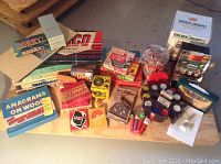 Full view of games and toys on table including board game boxes, card games, poker chips, and toy slot machine