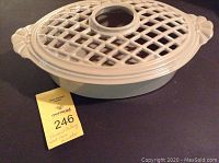 Photo of the assembled wood stove humidifier with cast iron lattice lid and cream glaze.
