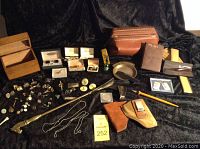 Overview of large men's accessory lot on fabric backdrop with wooden box and leather items