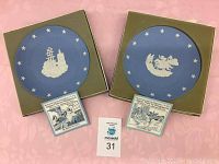 Two Wedgwood Jasperware decorative plates in original boxes with informational cards showing Boston Tea Party and Paul Revere's Ride designs.