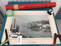 Signed framed painting of a coastal scene titled 'The South Shore, Nova Scotia' by James L. Kierstead, artwork displayed alongside a red storage tube and painter's tape.