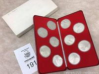 Ten medallions in red leather case with outer white box