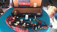Complete bagpipe set laid out in open case showing bag, pipes and blowpipe